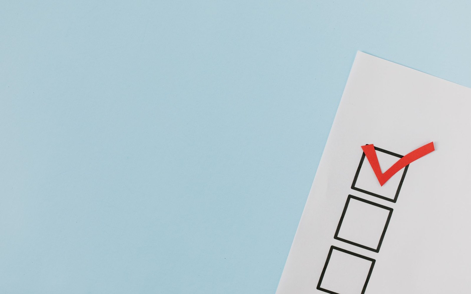 A checklist with three empty boxes, the top one marked with a red check