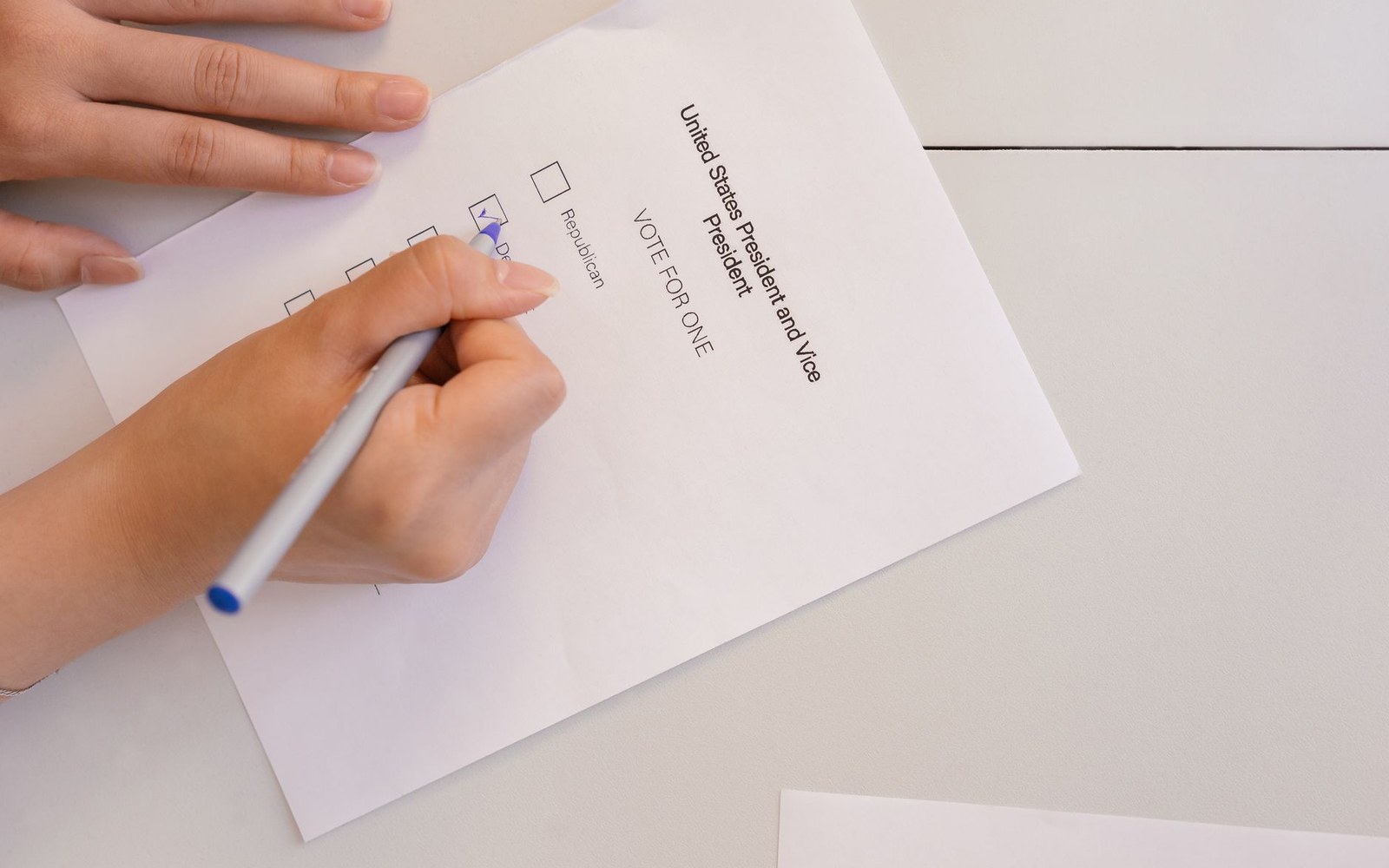 A hand marks a checkbox on a US presidential and vice presidential ballot